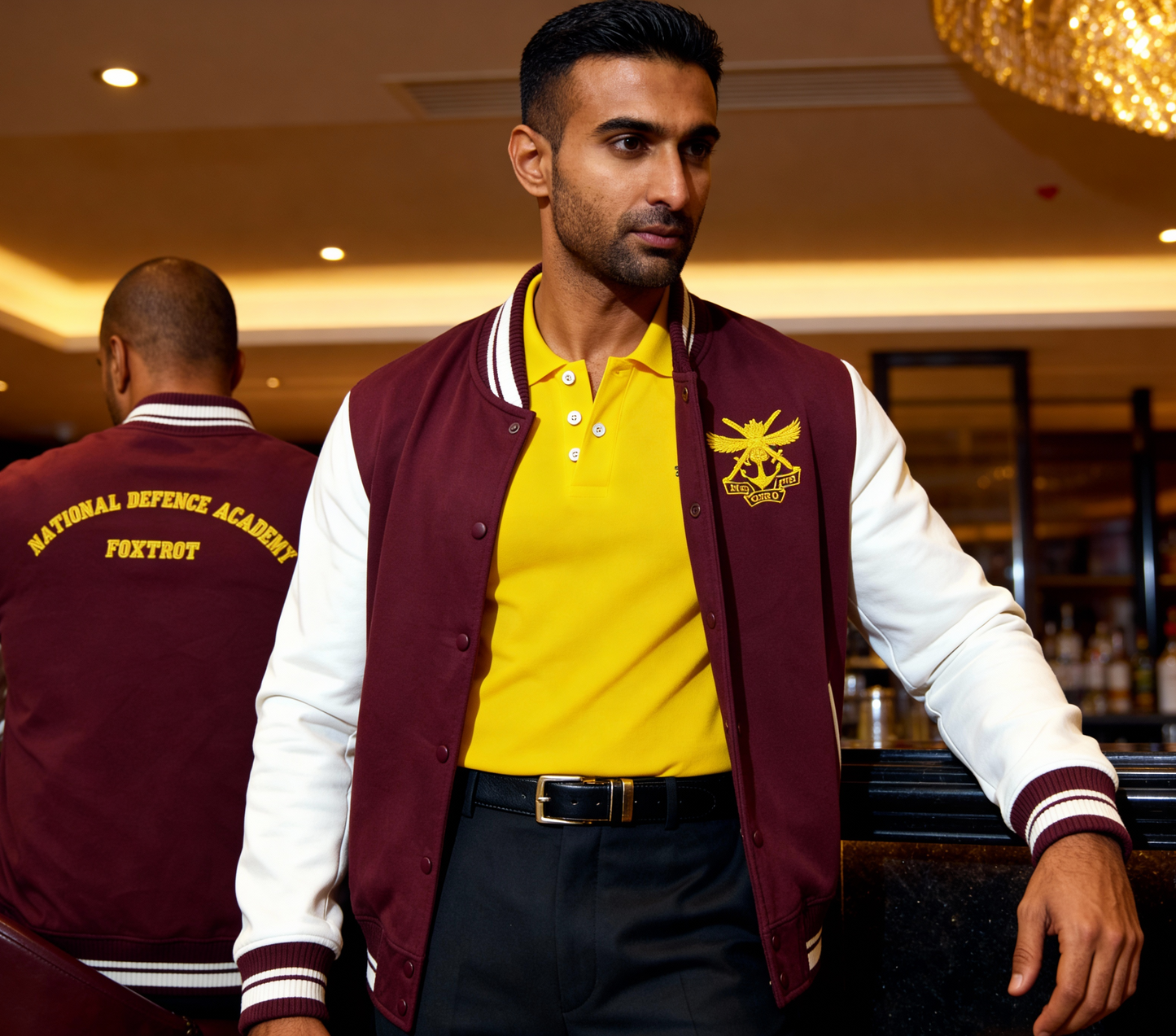 Man wearing a maroon and white varsity jacket with a yellow shirt in a bar setting